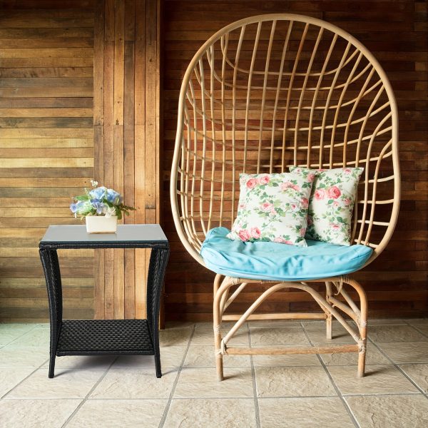 "A black four-line rattan double-layered side table with glass top, suitable for small living rooms in households